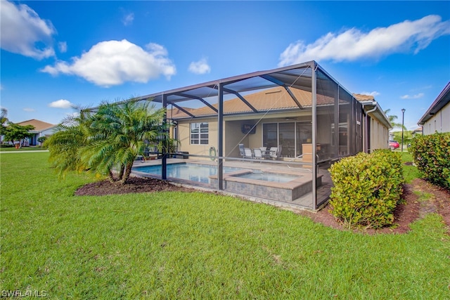 back of property with a lawn, glass enclosure, a swimming pool with hot tub, and a patio