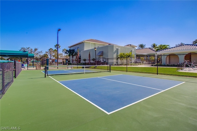 view of tennis court with basketball hoop