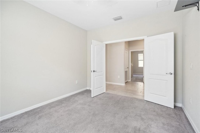 unfurnished bedroom featuring light carpet