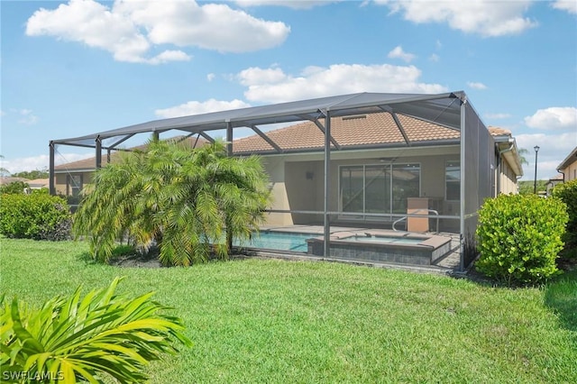 rear view of property with a pool with hot tub, a lanai, and a yard