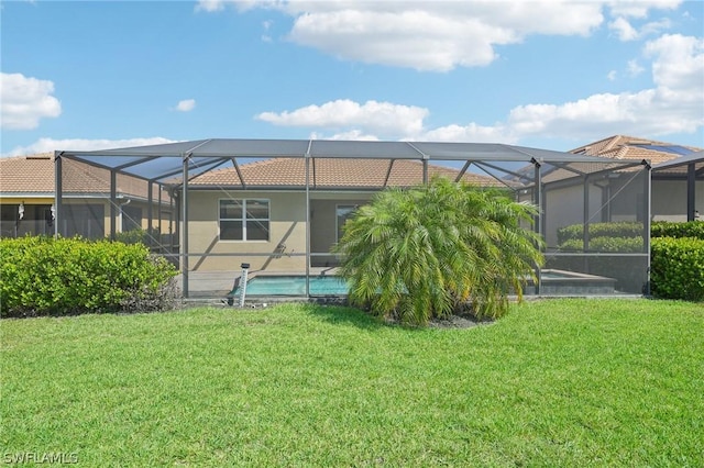 rear view of house with a lanai and a lawn