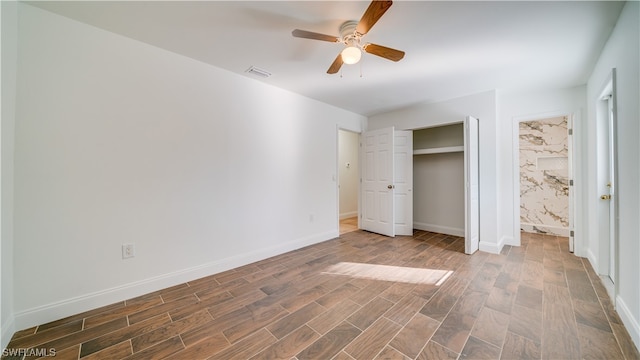 unfurnished bedroom with ensuite bathroom, ceiling fan, and hardwood / wood-style floors