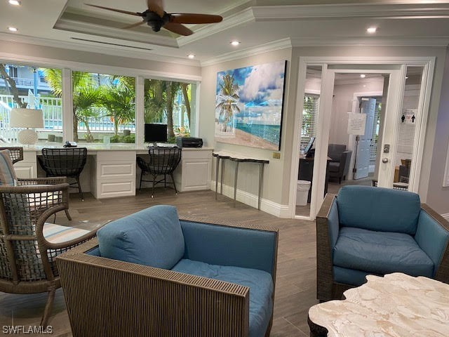 interior space with a tray ceiling, built in desk, and ceiling fan