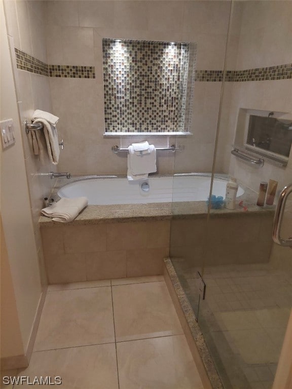 bathroom featuring independent shower and bath, tile walls, and tile patterned floors