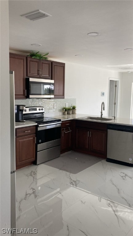 kitchen featuring dark brown cabinets, sink, and stainless steel appliances