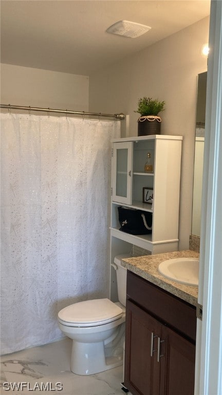 bathroom featuring walk in shower, vanity, and toilet