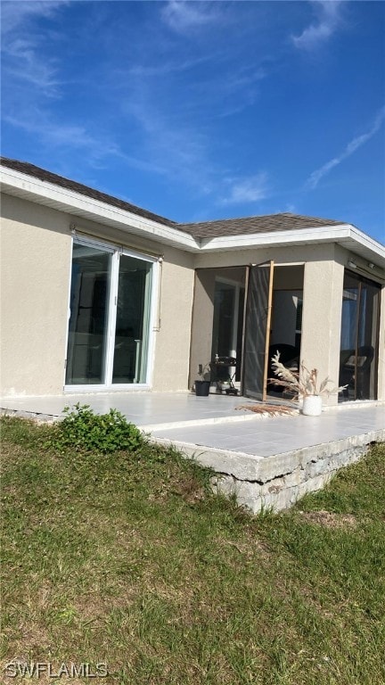 rear view of house with a yard and a patio area