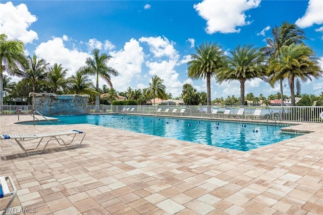 view of swimming pool with pool water feature and a patio