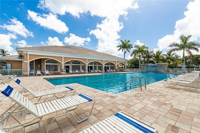 view of swimming pool with pool water feature and a patio area