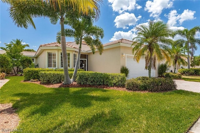 mediterranean / spanish home with a garage and a front lawn