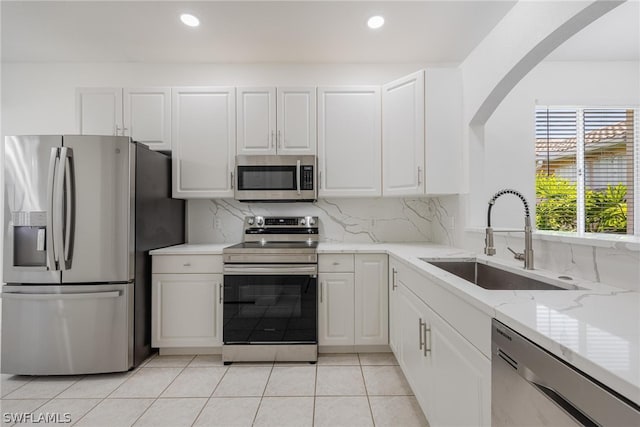 kitchen with white cabinetry, sink, backsplash, and appliances with stainless steel finishes