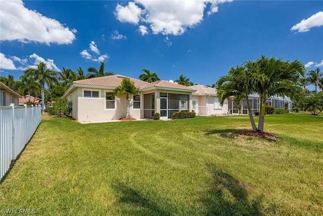 back of property featuring a yard and a sunroom