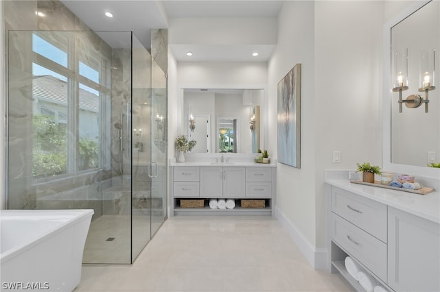 bathroom featuring tile flooring, independent shower and bath, and vanity