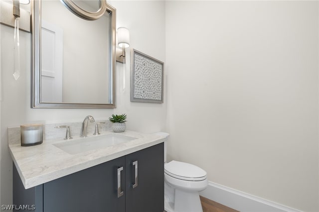 bathroom featuring hardwood / wood-style flooring, vanity, and toilet