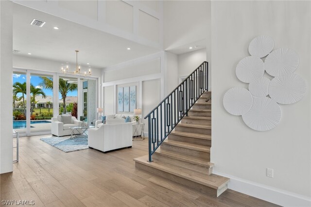 stairway featuring a notable chandelier and light hardwood / wood-style flooring