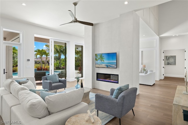 living room with ceiling fan and light hardwood / wood-style flooring