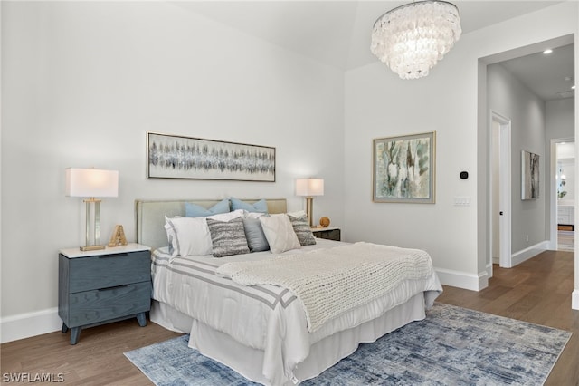 bedroom featuring an inviting chandelier and dark hardwood / wood-style flooring