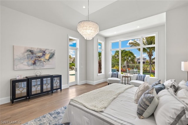 bedroom with a notable chandelier, access to exterior, and hardwood / wood-style floors