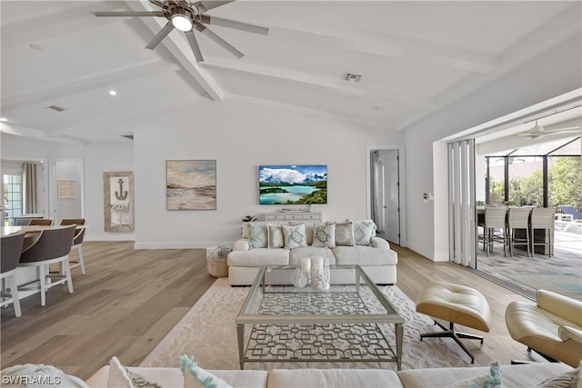 living room featuring lofted ceiling with beams, light hardwood / wood-style flooring, and ceiling fan