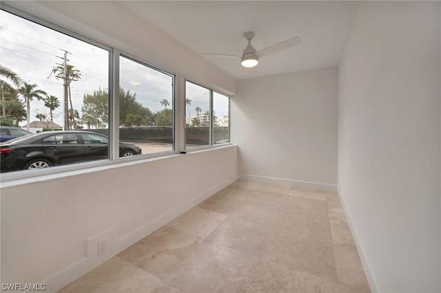 empty room featuring light tile flooring and ceiling fan