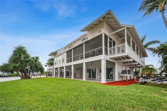 rear view of property with a yard and a sunroom