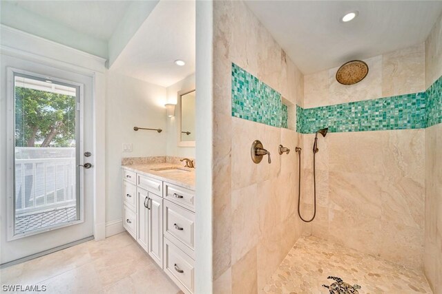 bathroom featuring vanity, tile patterned floors, and a tile shower