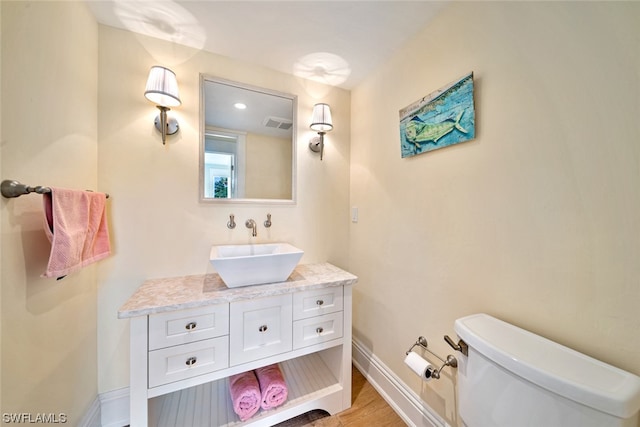 bathroom with wood-type flooring, toilet, and vanity