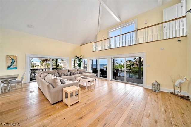 living room with high vaulted ceiling and light hardwood / wood-style floors