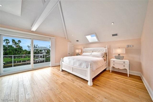 bedroom with vaulted ceiling with skylight, access to exterior, and light wood-type flooring