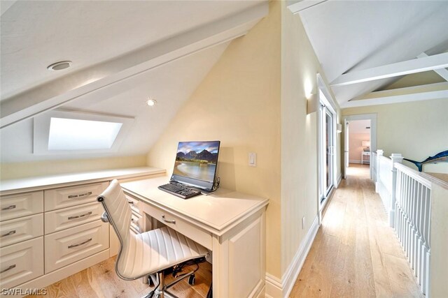 office area with light hardwood / wood-style flooring and lofted ceiling with skylight