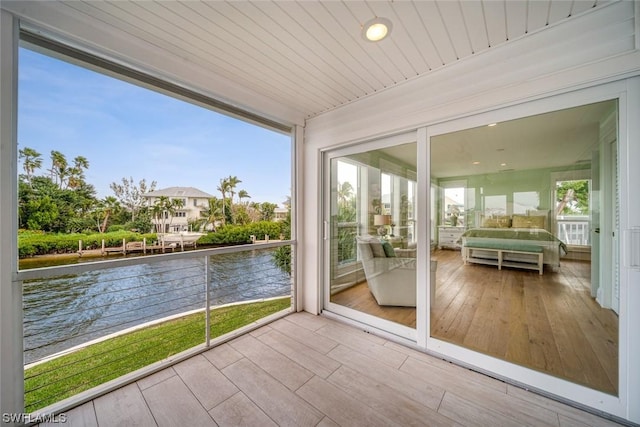 unfurnished sunroom featuring a water view