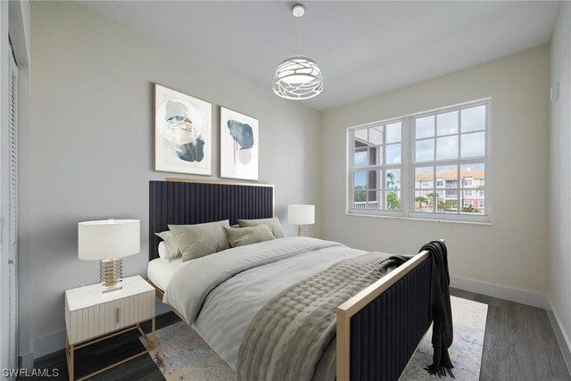 bedroom with dark hardwood / wood-style flooring and a closet