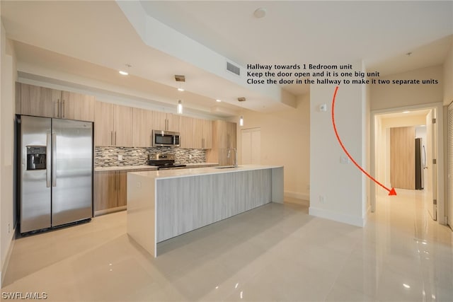 kitchen featuring light tile patterned flooring, light brown cabinets, backsplash, hanging light fixtures, and appliances with stainless steel finishes