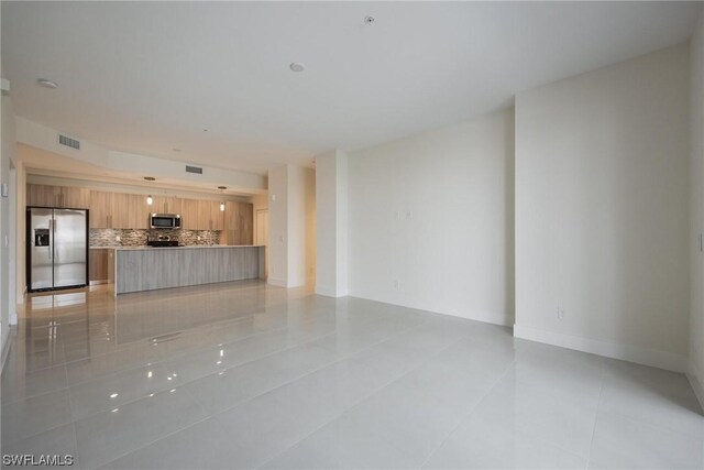 unfurnished living room featuring light tile patterned floors