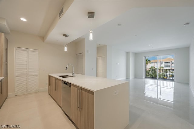 kitchen featuring stainless steel dishwasher, hanging light fixtures, sink, light tile patterned floors, and a kitchen island with sink