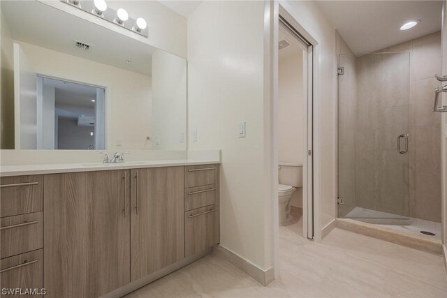 bathroom featuring vanity, toilet, tile patterned floors, and walk in shower