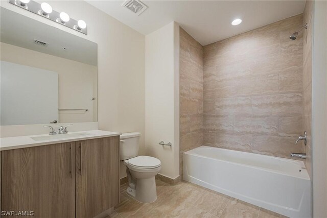 full bathroom with tile patterned flooring, tiled shower / bath combo, toilet, and vanity