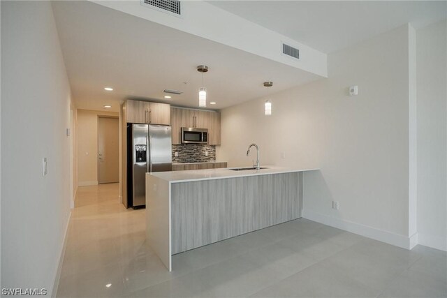 kitchen with light tile patterned floors, kitchen peninsula, stainless steel appliances, decorative backsplash, and decorative light fixtures