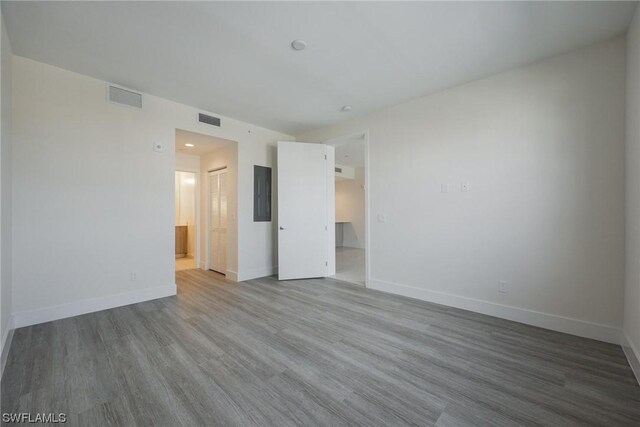 empty room featuring electric panel and hardwood / wood-style floors