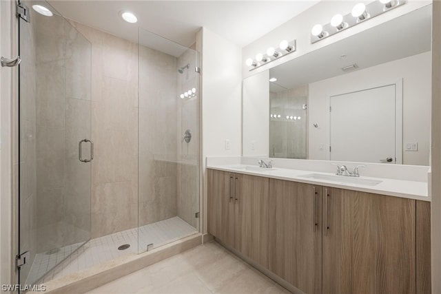 bathroom with double vanity, tile patterned flooring, and an enclosed shower