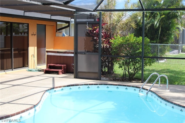 view of pool with a hot tub, glass enclosure, and a patio