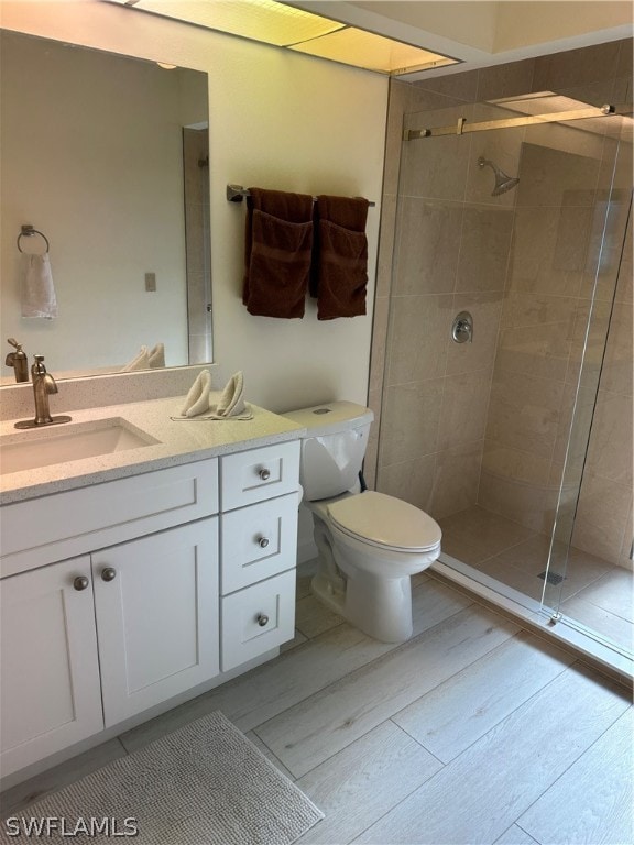 bathroom with vanity, toilet, and a tile shower