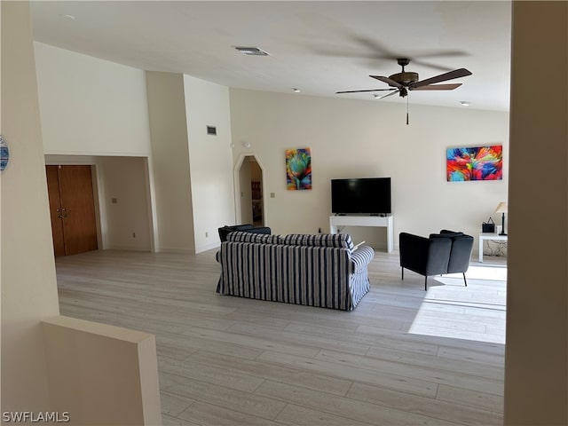 living room featuring high vaulted ceiling, ceiling fan, and light wood-type flooring