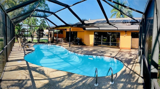 view of swimming pool featuring a lanai and a patio