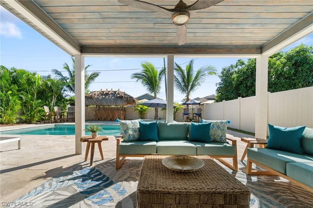 view of patio featuring ceiling fan, outdoor lounge area, and a fenced in pool