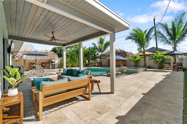 view of patio / terrace with an outdoor living space, ceiling fan, and a pool with hot tub