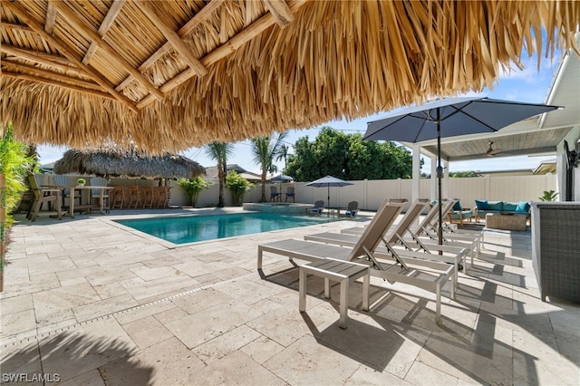 view of pool featuring a bar, an outdoor hangout area, and a patio area