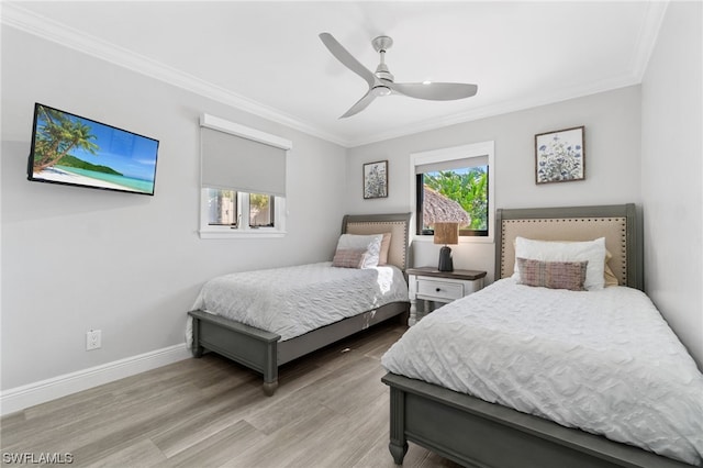 bedroom with multiple windows, crown molding, and light hardwood / wood-style floors