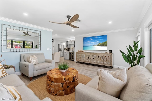 living room with ornamental molding, light hardwood / wood-style floors, and ceiling fan