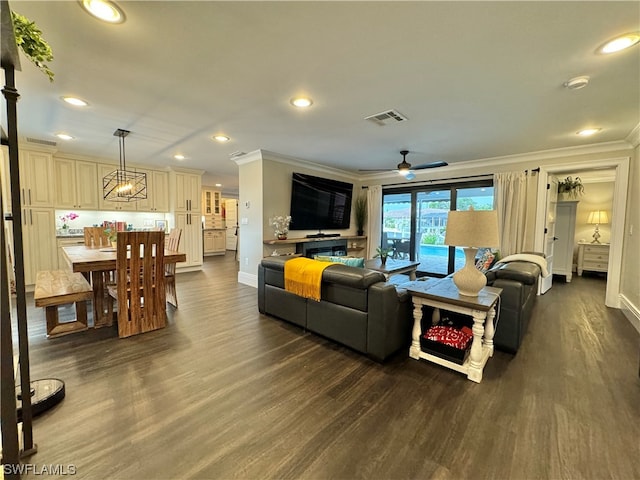 living room with crown molding, ceiling fan, and dark hardwood / wood-style floors